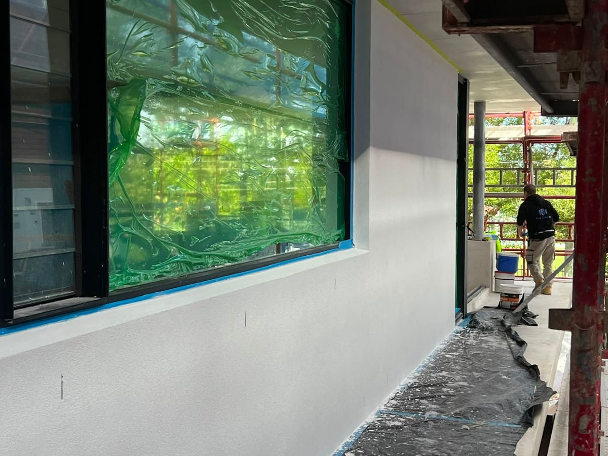 SPR Rendering tradesman working from scaffolding on a white texture rendered wall at a Sydney new build